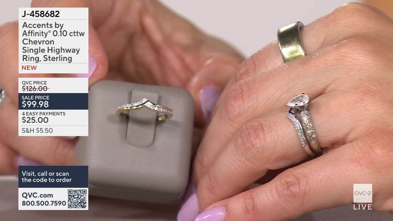 A delicate chevron ring with small diamonds sits on a display stand. On a person's hand, a pear-shaped diamond ring is stacked with a patterned band.