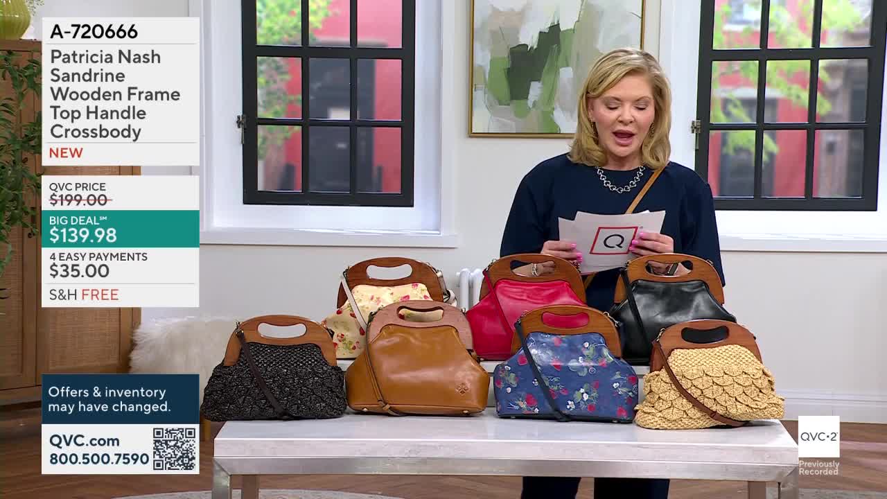 A woman on QVC2 holds up a card with a red Q as she presents several Patricia Nash crossbody bags. The bags, each with a wooden frame top handle, are lined up on a table in various colors and patterns.