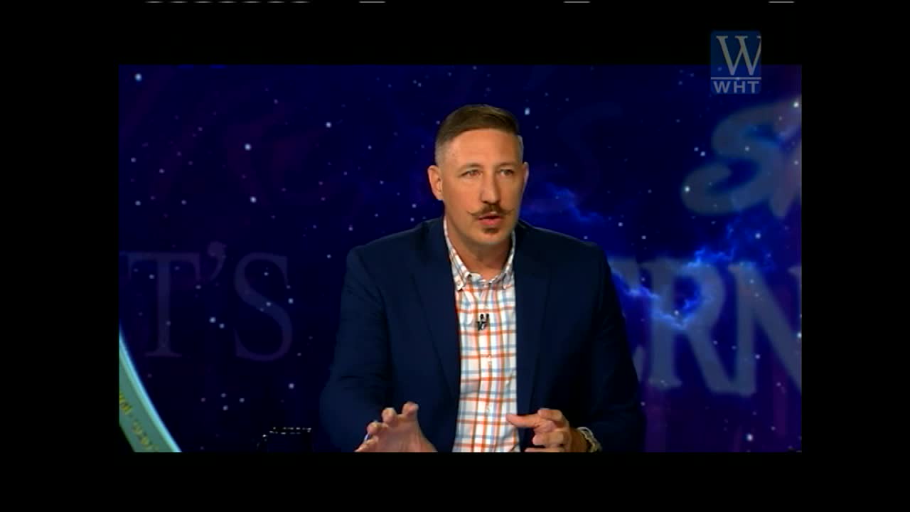 The man in the blue blazer gestures with both hands as he speaks. Behind him, the World Harvest TV logo sits above a cosmic-themed backdrop.
