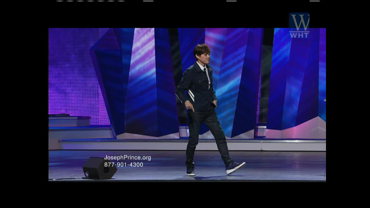 A man in a dark jacket and jeans strides across the stage, his hands in his pockets. The World Harvest TV logo is visible in the corner, and a website address scrolls at the bottom.
