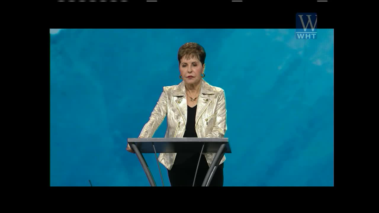 A woman in a shiny gold jacket stands behind a podium, speaking to an audience. Her message is broadcast on World Harvest TV.