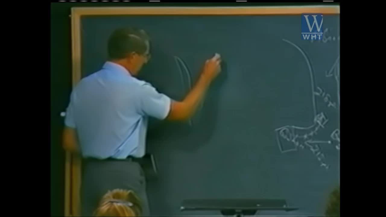 A man in a light blue shirt draws on a chalkboard. He's sketching a diagram, perhaps for a lesson on World Harvest TV.