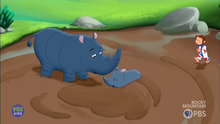 A large rhino nudges its baby, who's lying in the mud. Nearby, a boy in a white and red jumpsuit walks through the murky ground.