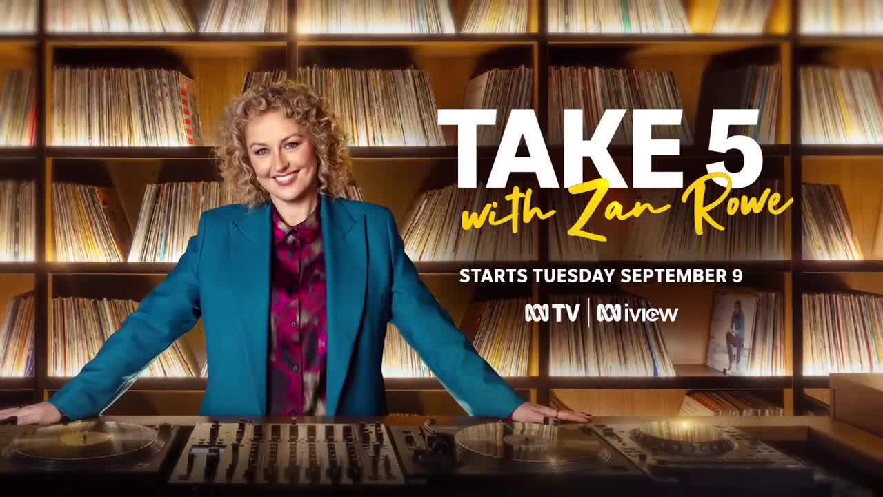 Zan Rowe smiles, leaning on a DJ setup, with a wall of records behind her. The ABC Australia show "Take 5" is about to start.
