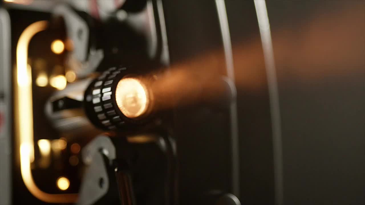 A bright, warm light bursts from the projector's lens, casting a soft glow. The beam of light extends outward, illuminating the surrounding area.
A bright, warm light bursts from the projector's lens, casting a soft glow. The beam of light extends outward, illuminating the surrounding area.