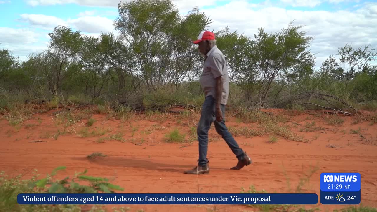 A man in a red and white cap walks along a red dirt track, his boots kicking up a little dust. The Australian bush stretches out behind him, under a partly cloudy sky.
A man in a red and white cap walks along a red dirt track, his boots kicking up a little dust. The Australian bush stretches out behind him, under a partly cloudy sky.