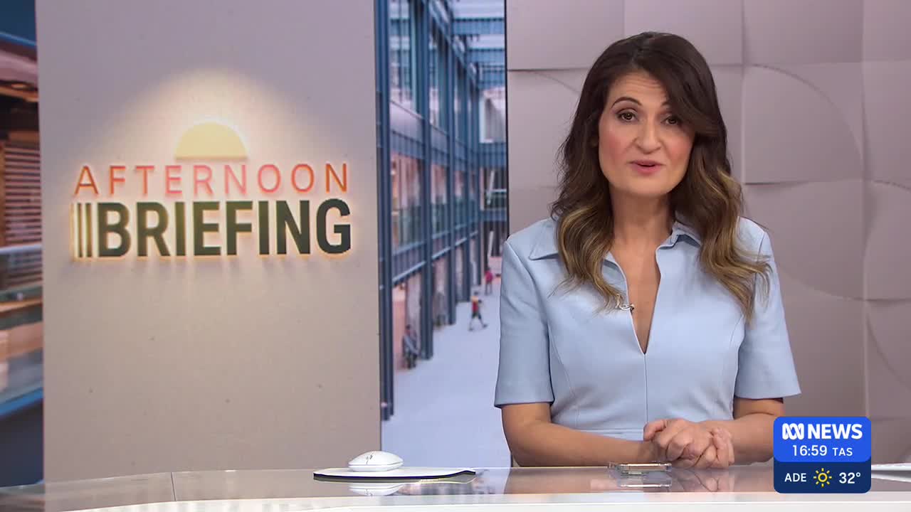 The ABC News presenter, wearing a light blue dress, is speaking directly to the camera. Behind her, the "Afternoon Briefing" logo glows, and a city scene is visible on a screen.
The ABC News presenter, wearing a light blue dress, is speaking directly to the camera. Behind her, the "Afternoon Briefing" logo glows, and a city scene is visible on a screen.