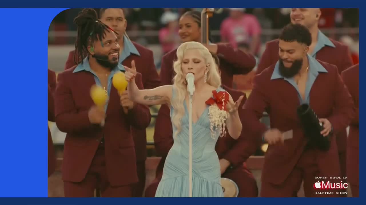 A singer in a pale blue gown stands at a microphone, her blonde hair styled back. Backing musicians in matching maroon suits and blue shirts shake maracas and play instruments.
