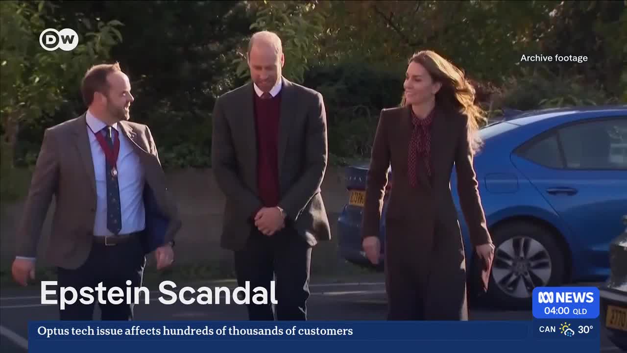 A man in a suit and tie walks with a woman in a brown suit, their heads slightly bowed. Another man, also in a suit, walks beside them, looking to his left.