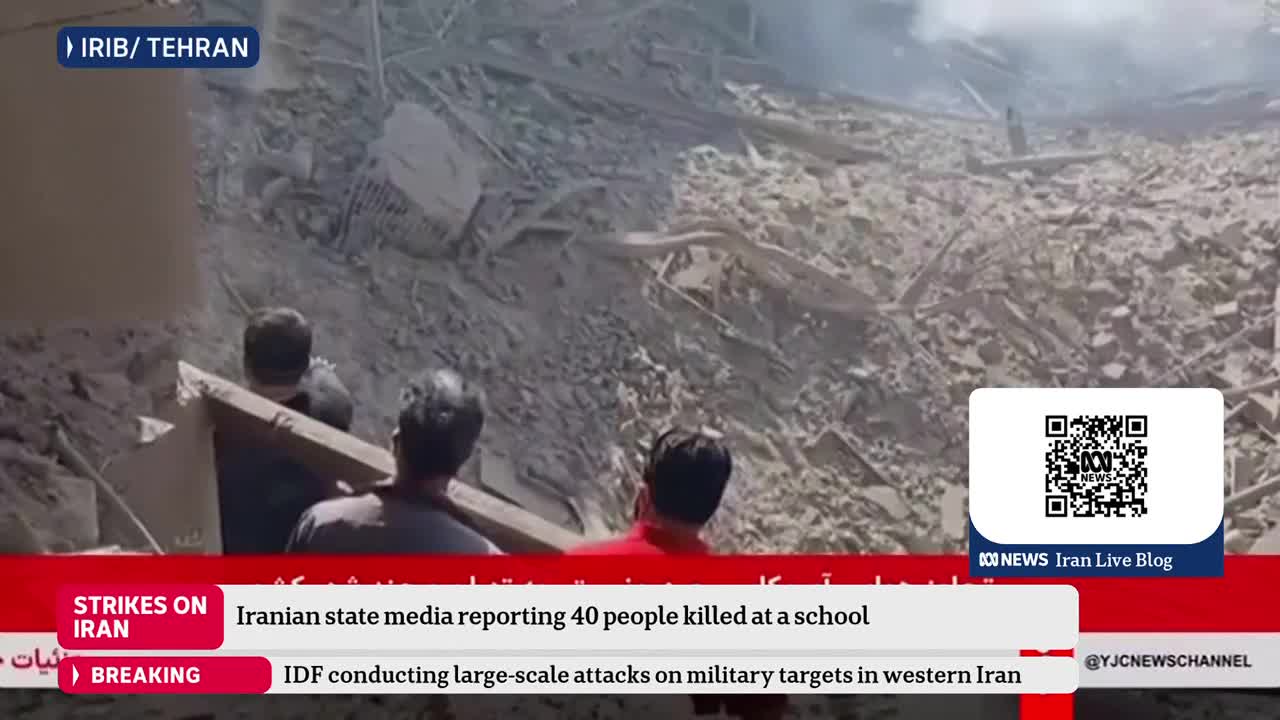 Men are carrying a large wooden beam through a debris-filled area. Dust hangs in the air, obscuring the full extent of the destruction. Men are carrying a large wooden beam through a debris-filled area. Dust hangs in the air, obscuring the full extent of the destruction.