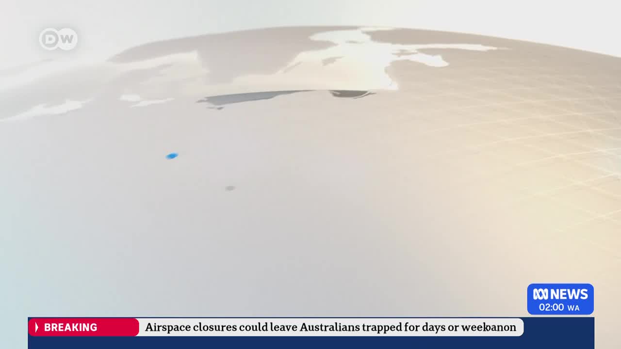 A blue dot, representing a flight, moves across a pale, stylized map of the world. The ABC News ticker at the bottom reports that airspace closures could leave Australians stranded. A blue dot, representing a flight, moves across a pale, stylized map of the world. The ABC News ticker at the bottom reports that airspace closures could leave Australians stranded.