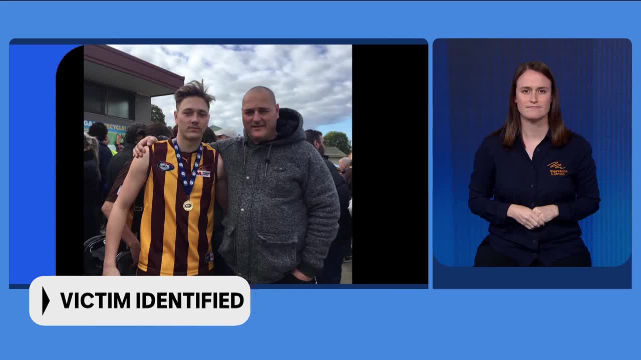 A young man in a striped football jersey, wearing a medal, stands with his arm around an older man. A sign below them reads "VICTIM IDENTIFIED."