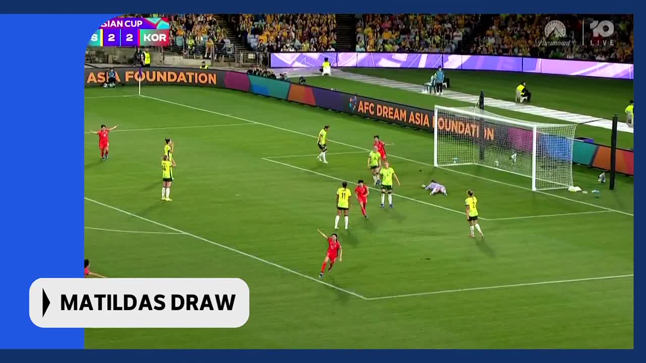 A player in red sprints towards the goal, her teammates in yellow spread out on the field. The scoreboard shows the Matildas have drawn their match.