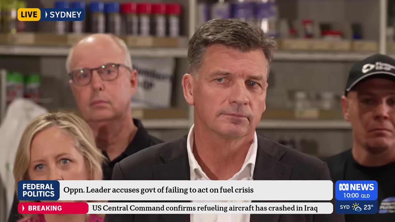 A man in a dark suit stands at a podium, looking directly ahead. Behind him, others stand with serious expressions. A chyron at the bottom of the screen reads "FEDERAL POLITICS" and "Oppn. Leader accuses govt of failing to act on fuel crisis."