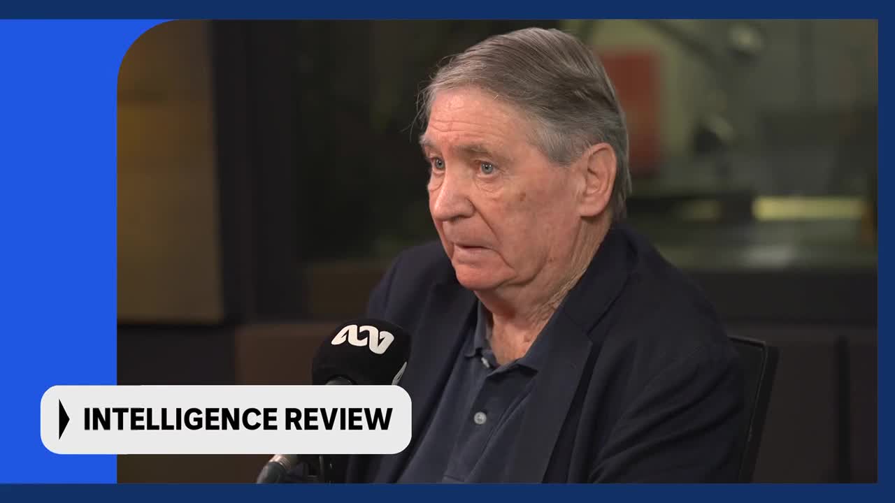 An older gentleman with grey hair speaks into an ABC microphone. He wears a dark jacket over a blue collared shirt.