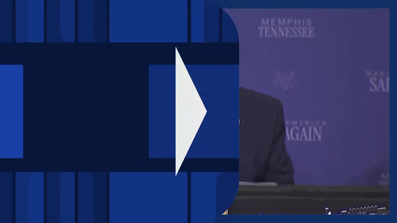 A man in a dark suit stands behind a podium. The backdrop behind him displays "MEMPHIS TENNESSEE" and "MAKE AMERICA AGAIN."