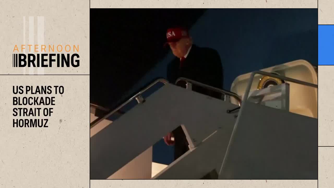A man in a red "USA" cap walks down airplane stairs. The ABC Australia news chyron reads "US PLANS TO BLOCKADE STRAIT OF HORMUZ."