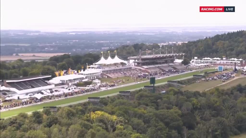 The grandstand and track are packed with people, and the course looks ready for the next race. A Racing.com live stream is underway, broadcasting the event to viewers.
