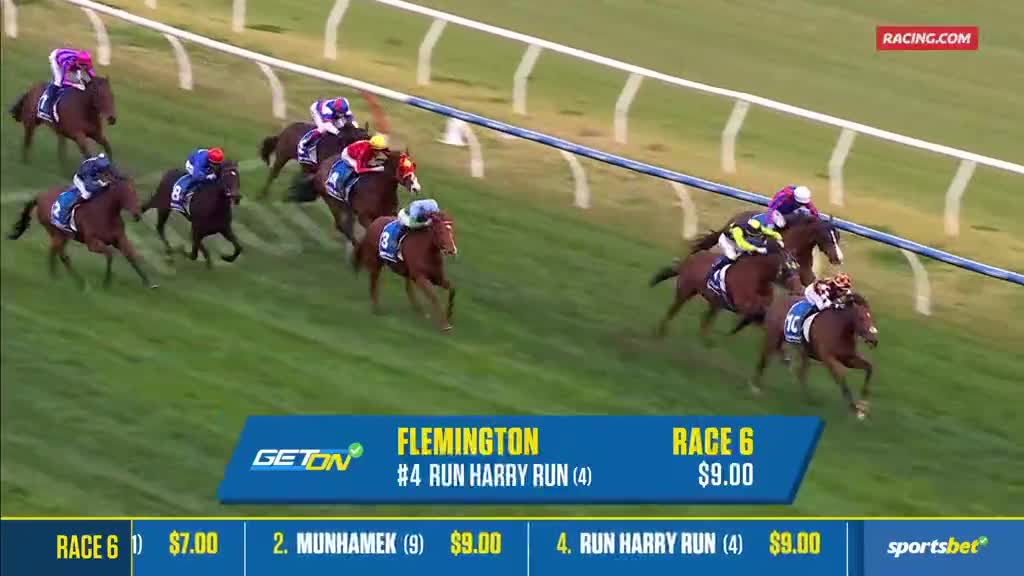 The horses are rounding the bend at Flemington, the jockeys urging them on.  Run Harry Run, at $9.00, is in the lead, according to Racing.com.
