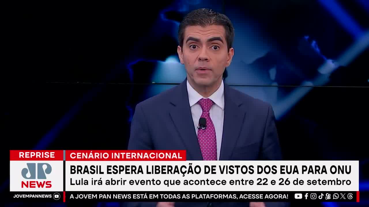 A news anchor, wearing a suit and tie, speaks directly to the camera against a dark background. The Jovem Pan News logo and a headline about Brazil and the UN are visible on the screen.
