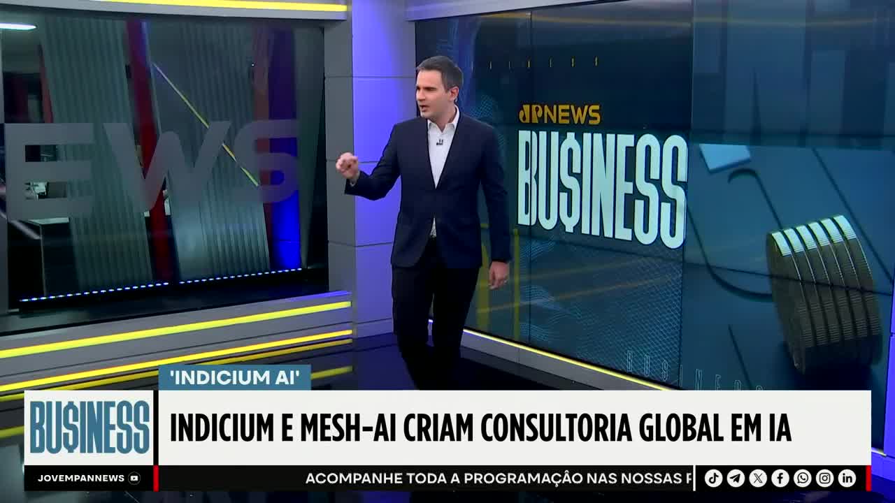 A man in a dark suit gestures emphatically on the Jovem Pan News set. The screen behind him displays "BUSINESS" in large letters, with the story about AI consulting below.
A man in a dark suit gestures emphatically on the Jovem Pan News set. The screen behind him displays "BUSINESS" in large letters, with the story about AI consulting below.