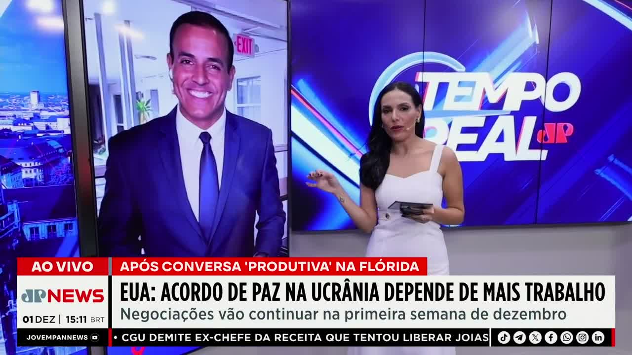 A woman in a white dress stands in front of a blue backdrop, gesturing towards a screen showing a man in a suit. Below, the Jovem Pan News logo and headlines about Ukraine are displayed.
A woman in a white dress stands in front of a blue backdrop, gesturing towards a screen showing a man in a suit. Below, the Jovem Pan News logo and headlines about Ukraine are displayed.