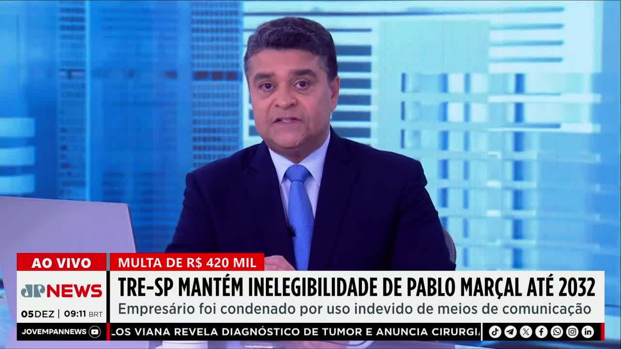 A man in a navy suit and blue tie speaks directly to the camera, delivering the news from Jovem Pan News. The headline below him announces the ineligibility of Pablo Marçal in Brazil.
A man in a navy suit and blue tie speaks directly to the camera, delivering the news from Jovem Pan News. The headline below him announces the ineligibility of Pablo Marçal in Brazil.