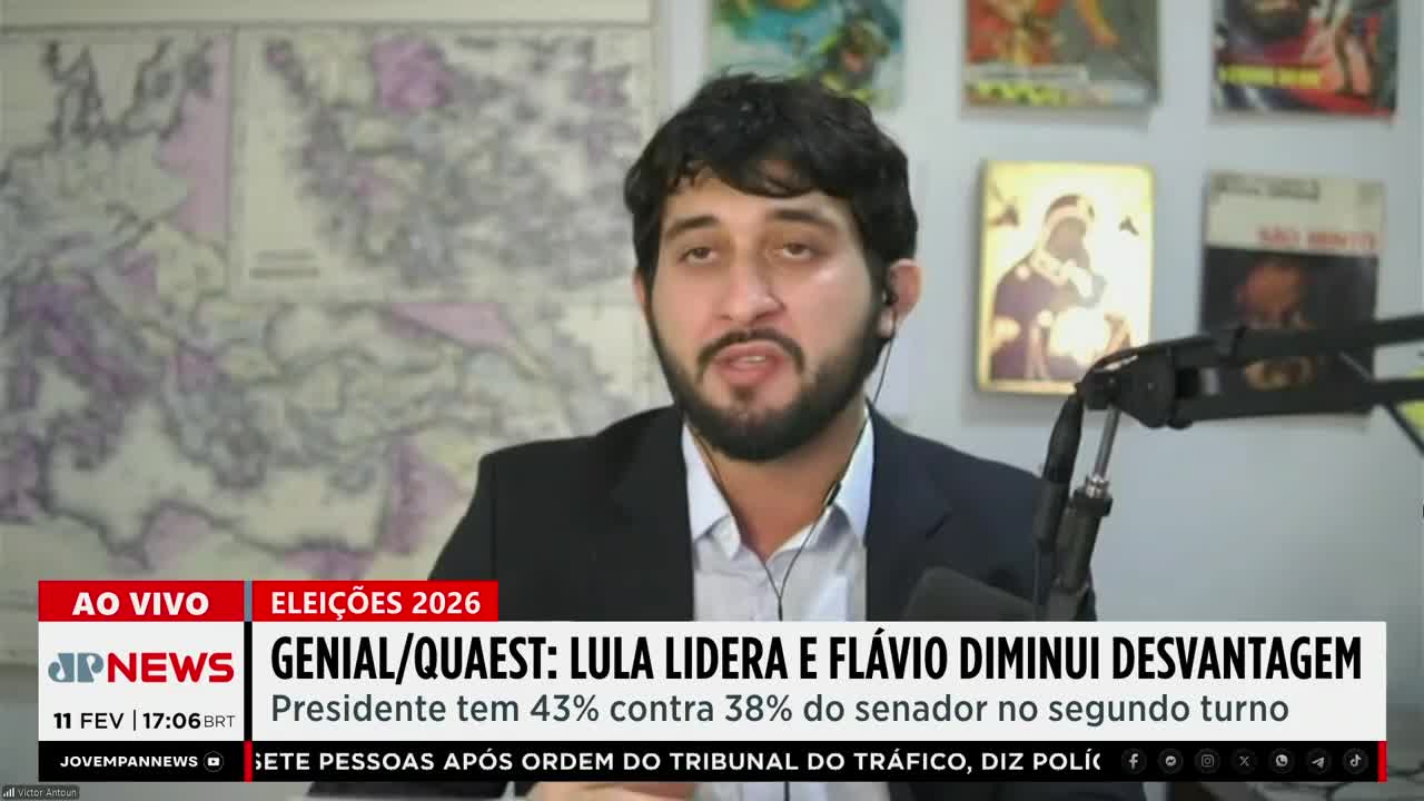 A man in a suit speaks into a microphone, a map of Europe behind him. Text overlays announce election results and news from Jovem Pan News. A man in a suit speaks into a microphone, a map of Europe behind him. Text overlays announce election results and news from Jovem Pan News.