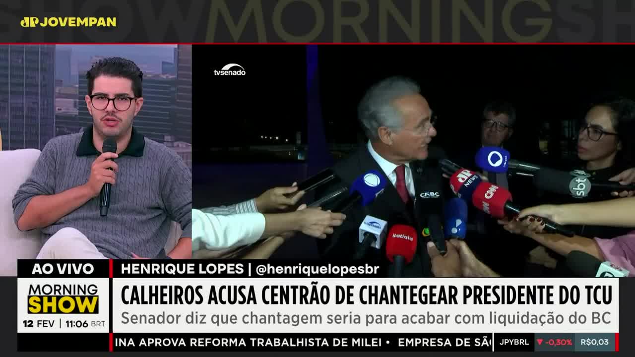 A man in a suit is surrounded by microphones, speaking to reporters. On the left, a man with glasses is on a couch, holding a microphone. A man in a suit is surrounded by microphones, speaking to reporters. On the left, a man with glasses is on a couch, holding a microphone.