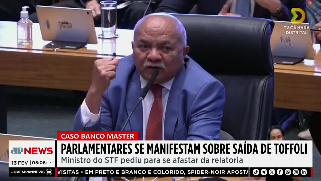 A man in a blue suit and red tie speaks into a microphone, his fist raised. A news chyron from Jovem Pan News identifies the topic as "PARLIAMENTARIANS MANIFEST ON TOFFOLI'S DEPARTURE." A man in a blue suit and red tie speaks into a microphone, his fist raised. A news chyron from Jovem Pan News identifies the topic as "PARLIAMENTARIANS MANIFEST ON TOFFOLI'S DEPARTURE."