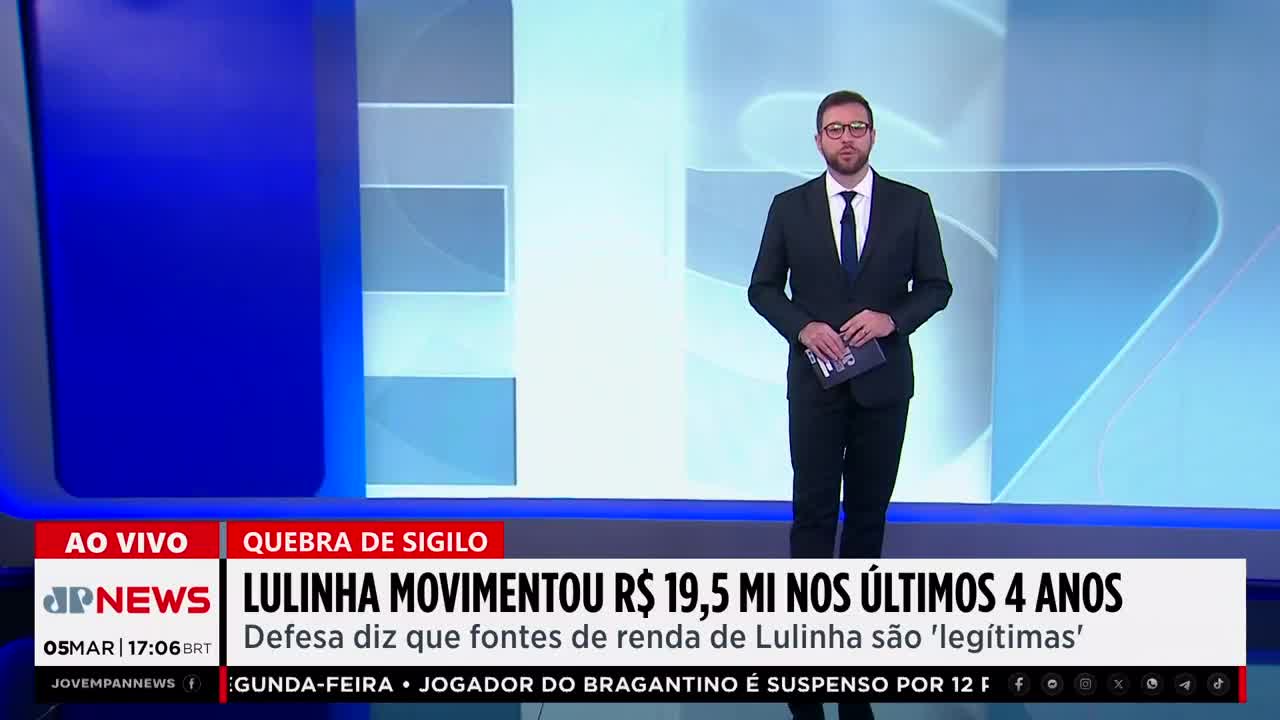 A man in a suit stands in front of a blue screen with news graphics. The Jovem Pan News logo is visible, along with a headline about financial transactions.