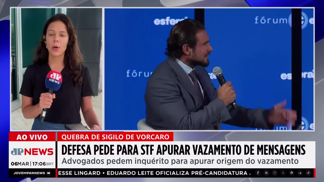 A reporter stands with a Jovem Pan News microphone, while a man in a suit speaks into a microphone on a blue background. The screen displays news headlines about a legal inquiry.
