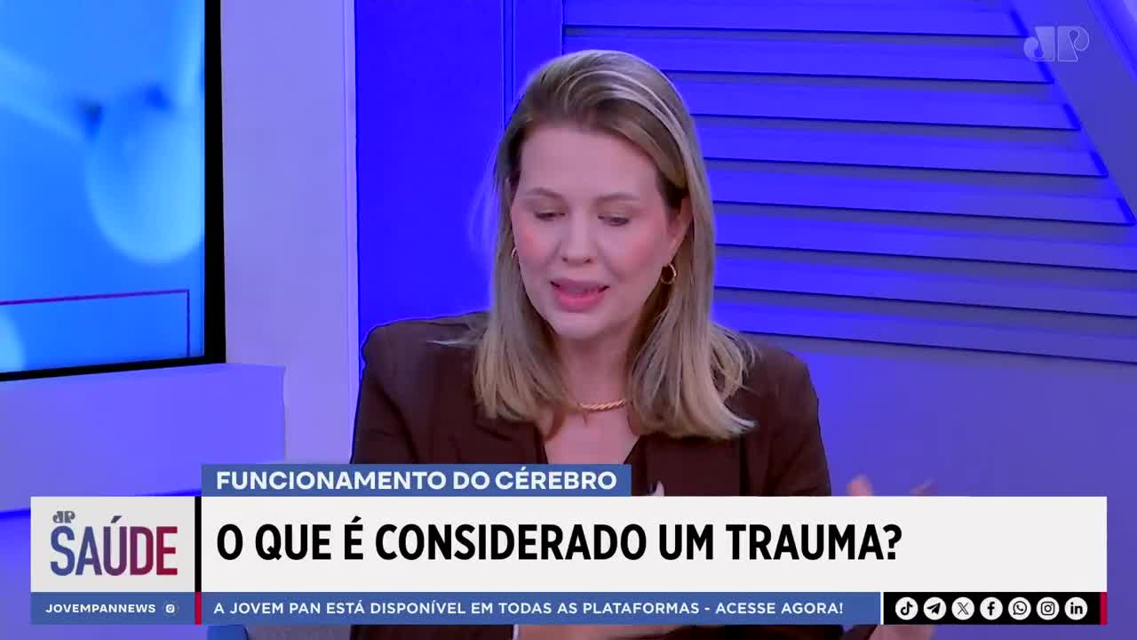 A woman with blonde hair, wearing a brown blazer, speaks animatedly. A graphic overlay from Jovem Pan News displays "O QUE É CONSIDERADO UM TRAUMA?" and "SAÚDE."