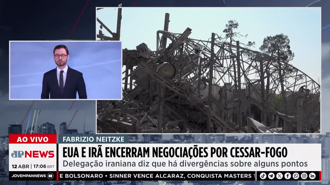 The skeletal remains of a building stand against a bright sky, twisted metal and debris piled high. On a screen, a newscaster in a suit reports on the situation.