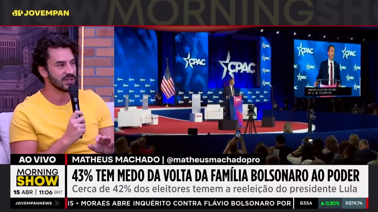 A man in a yellow shirt speaks into a microphone on a Jovem Pan News broadcast. On the screen behind him, a speaker addresses a crowd at a CPAC event.