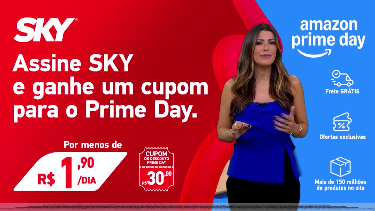 A woman in a blue top gestures towards the camera, standing in front of a red and blue backdrop. The screen advertises a SKY promotion for Amazon Prime Day, with text in Portuguese.
