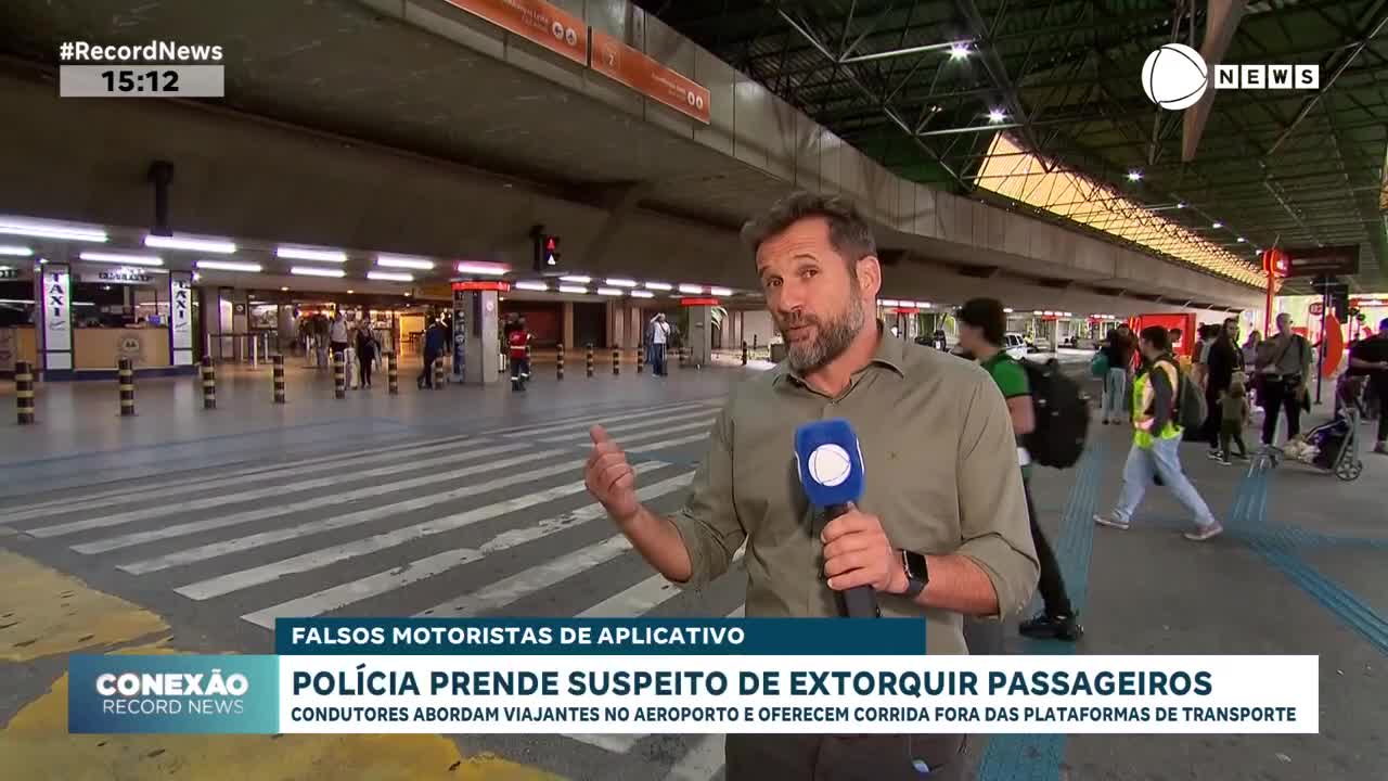 A reporter from Record News stands in front of a busy terminal, gesturing toward the entrance where people are walking in and out. The news segment is about fake drivers extorting passengers.
