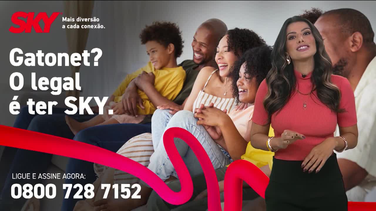 A woman in a coral shirt stands in front of a family laughing on a couch. The Record News logo is visible in the top left corner.