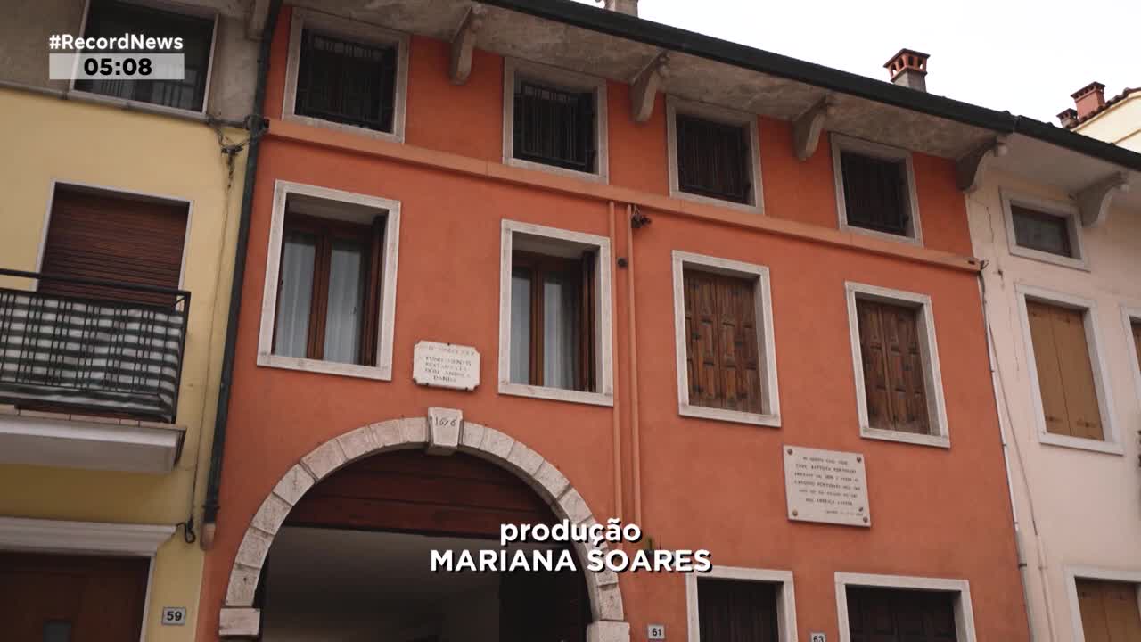 The Record News broadcast shows a building with an arched entryway. The text "produção MARIANA SOARES" appears across the bottom of the screen.