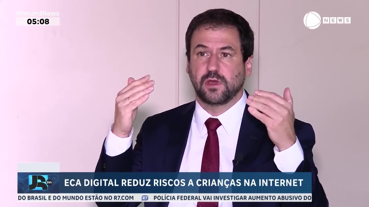 A man in a suit gestures with his hands, explaining something on Record News. The screen displays "ECA DIGITAL REDUZ RISCOS A CRIANÇAS NA INTERNET."