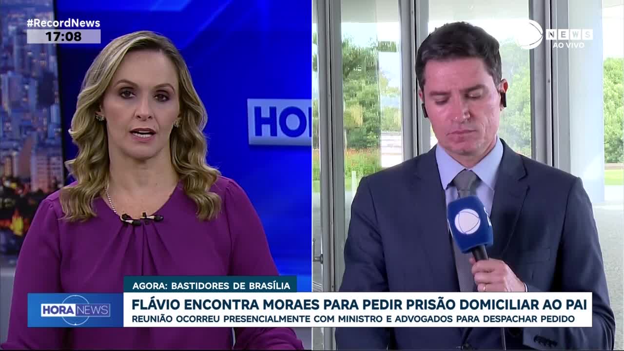 A woman in a purple blouse stands against a blue screen, speaking. To her right, a man in a suit holds a microphone, looking down. The Record News broadcast displays text about a meeting in Brasília.