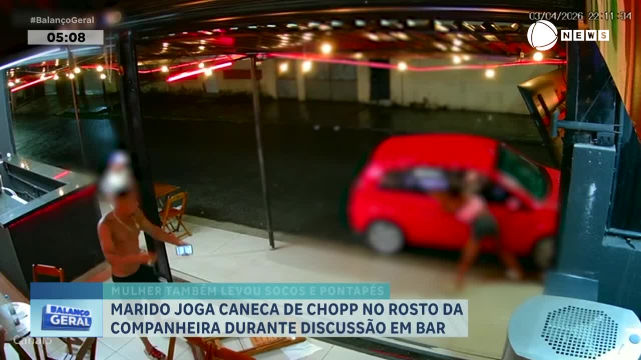 A man stands outside a bar, holding a phone. A red car is parked nearby, and a woman is leaning into its open door. A man stands outside a bar, holding a phone. A red car is parked nearby, and a woman is leaning into its open door.