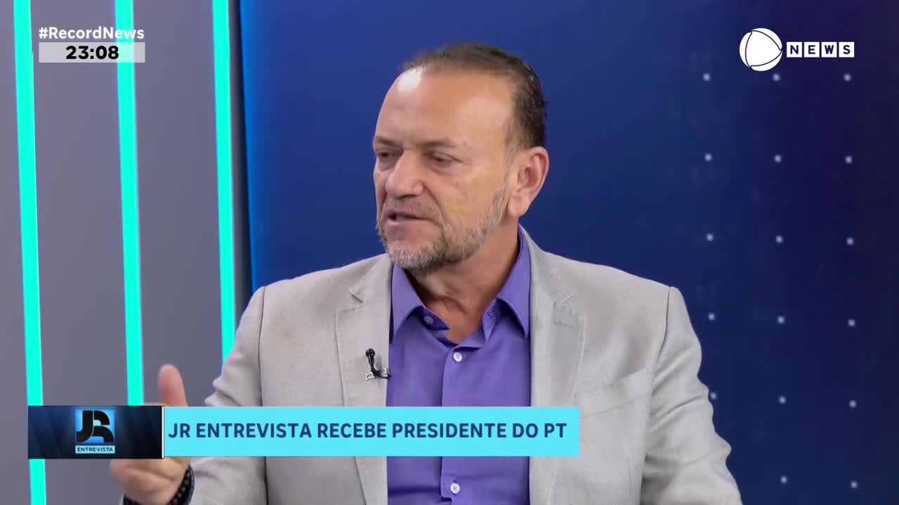 The man in the light gray suit gestures with his left hand as he speaks. A graphic at the bottom of the screen indicates this is a Record News interview with the president of PT.