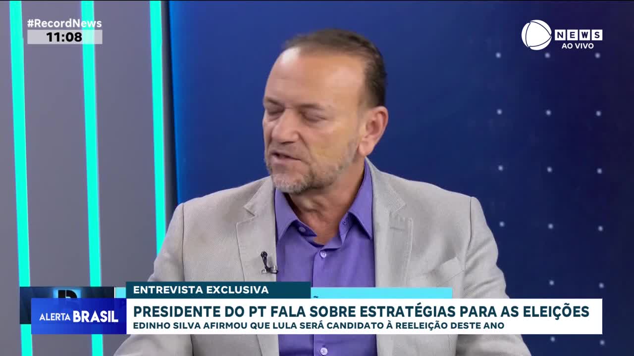 A man in a light gray suit jacket and purple shirt speaks into a microphone. Text on the screen indicates this is an exclusive interview on Record News about election strategies in Brazil.
