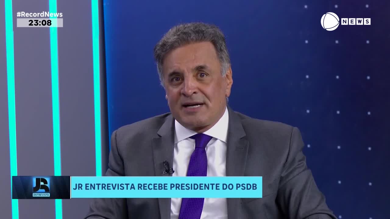 A man in a suit and purple tie speaks directly to the camera. On screen, the Record News logo and the text "JR ENTREVISTA RECEBE PRESIDENTE DO PSDB" are visible.