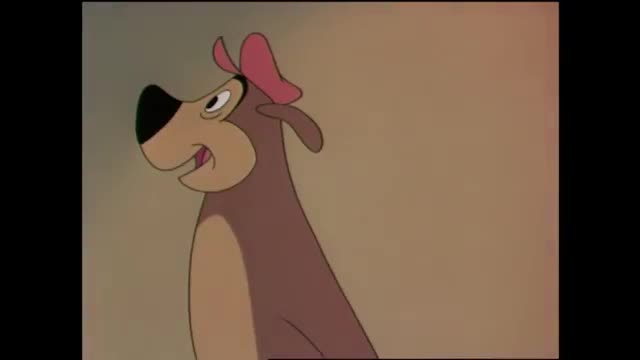 A brown dog with a pink bow on its head looks to its left, its mouth slightly open. The background is a muted tan.