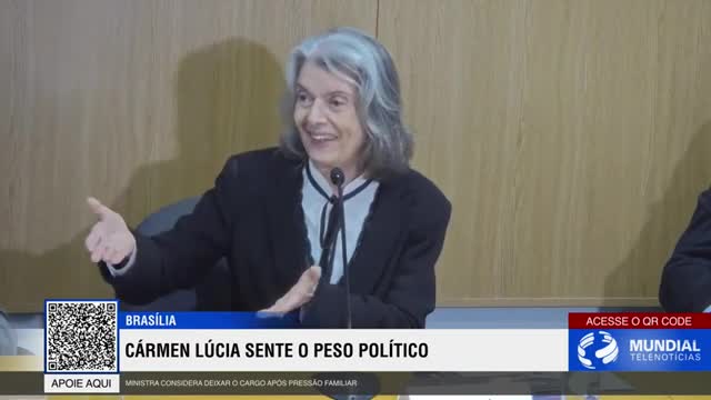 A woman with long grey hair, dressed in a black blazer and white blouse, gestures with her hands while speaking. A news ticker from Rede SPTV in Brazil scrolls across the bottom of the screen, reporting on Carmen Lúcia feeling political pressure.