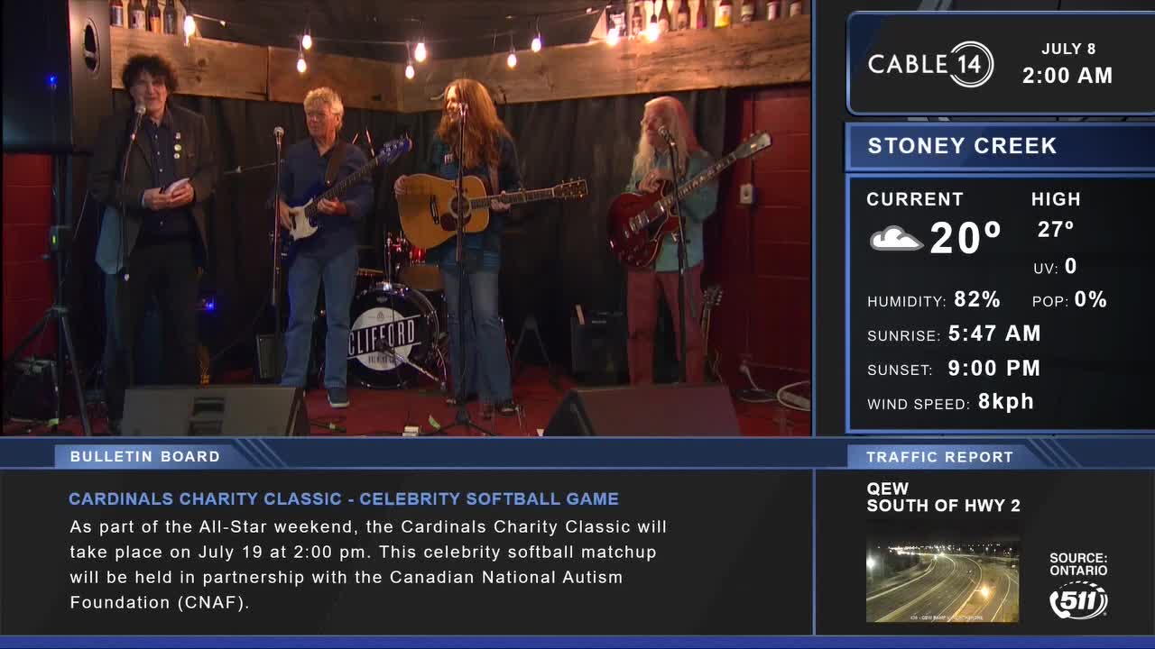 A band is set up on a small stage, with the Cable 14 logo in the corner. The guitarist on the right is about to play a solo.
