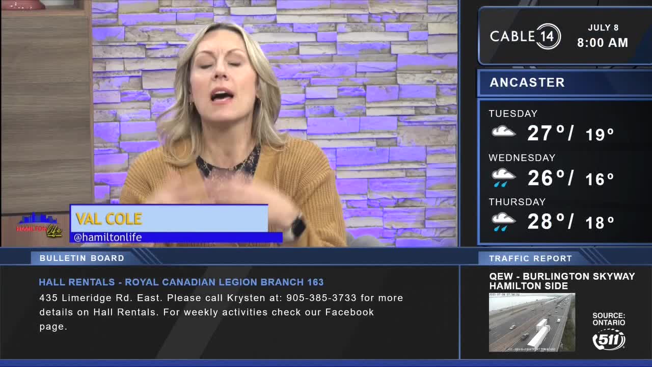 Val Cole from Cable 14 Hamilton is speaking, her hands gesturing as she talks. The screen shows the weather forecast for Ancaster, Ontario, and a traffic report.
