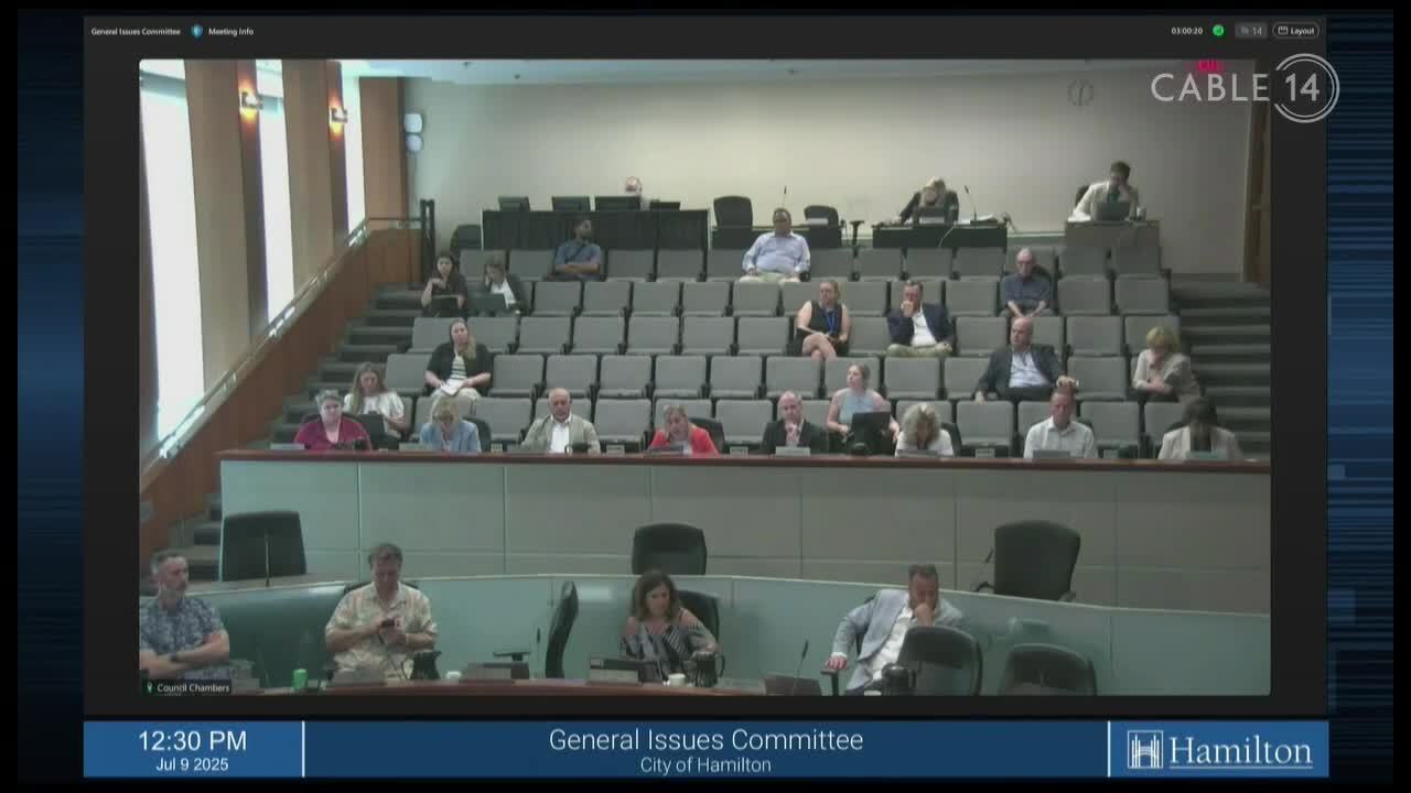 Cable 14 Hamilton is broadcasting a meeting of the General Issues Committee, with people seated in rows of chairs. The camera is focused on the panel at the front of the room, where several people are seated at a table.
